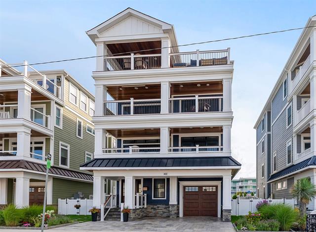 A modern, multi-story house with balconies and large windows.